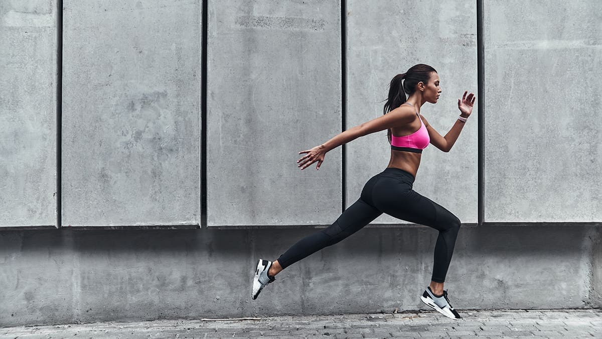 Pushing to the limit. Modern young woman in sports clothing jump