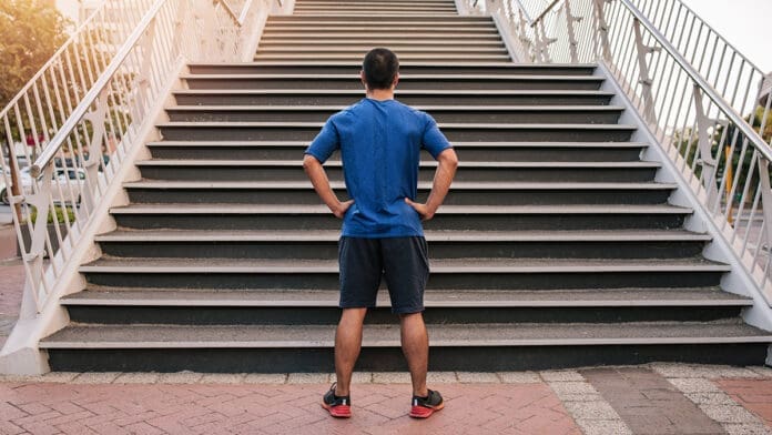 Young athletic man preparing to run up steep stairs