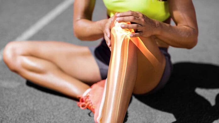 Low section of sportswoman suffering from knee pain